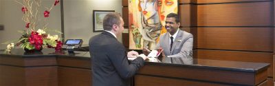 Two people talking at hotel front desk