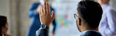 A person raising their hand in a meeting